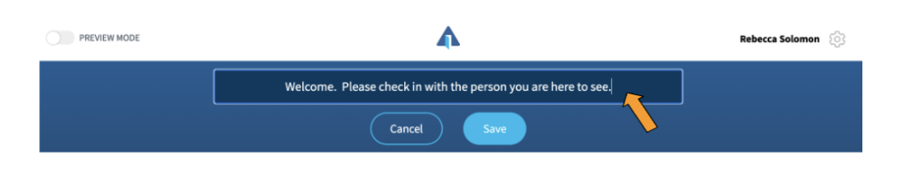 A screenshot showing an editable field in which the words "Welcome. Please check in with the person you are here to see" are entered. There is an orange arrow pointing to the field. Under it is a dark blue button labeled "Cancel" and a brighter blue button labeled "Save".